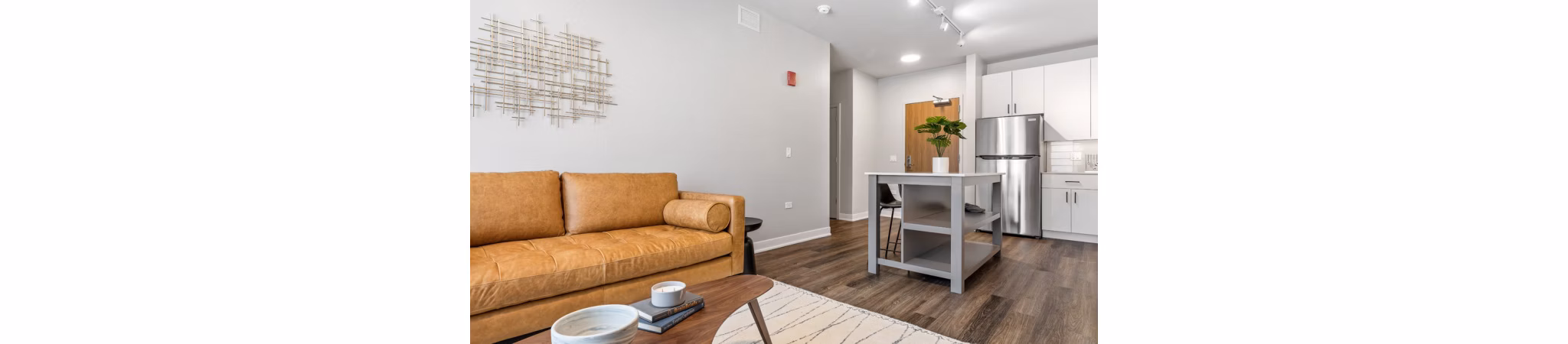 Contemporary living room featuring sleek furniture and large window views at District 1860 Apartments