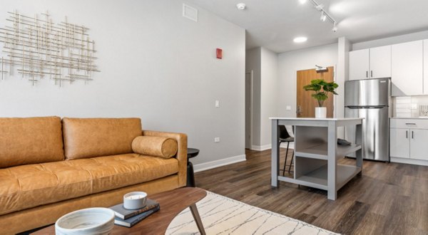 Contemporary living room featuring sleek furniture and large window views at District 1860 Apartments