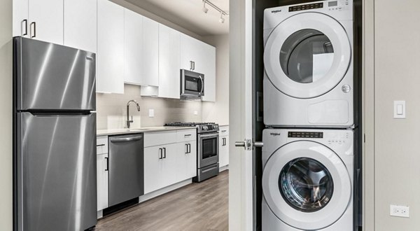 Laundry room with modern appliances at District 1860 Apartments