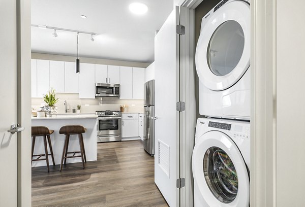 Laundry room with modern appliances at District 1860 Apartments
