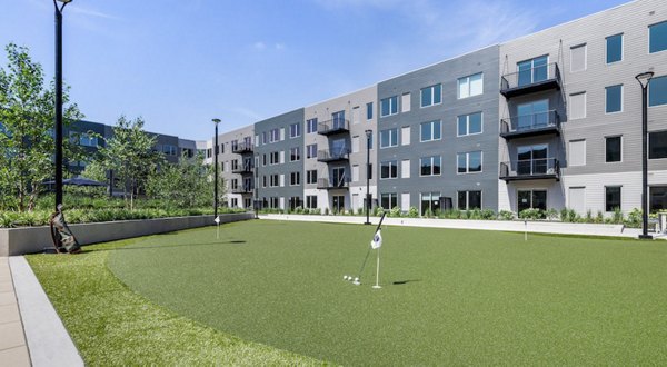 Putting green at District 1860 Apartments offering leisure and recreational activities for residents