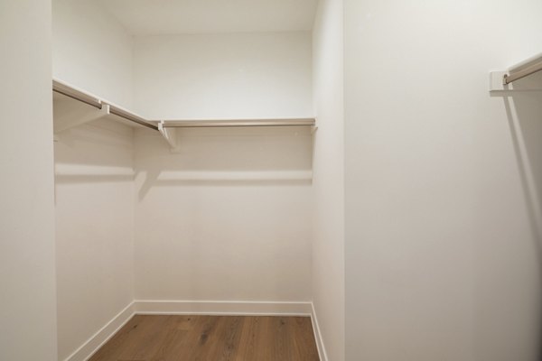 Elegant walk-in closet with ample shelving and mirror in The Alfred Apartments