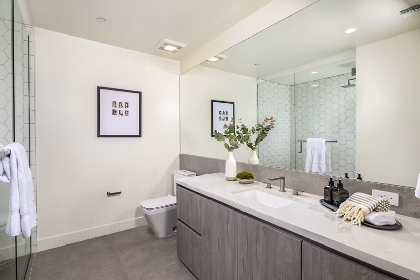 The Alfred Apartments: Modern bathroom featuring sleek cabinetry and large mirror