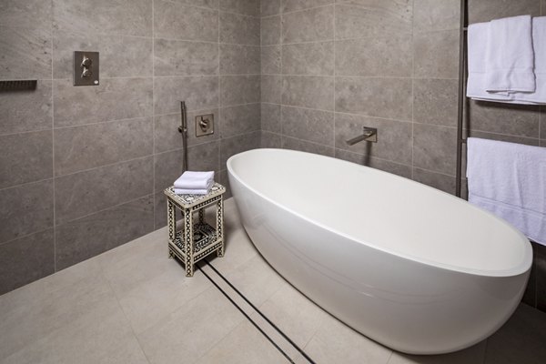 Modern bathroom with marble countertops and glass shower at The Alfred Apartments