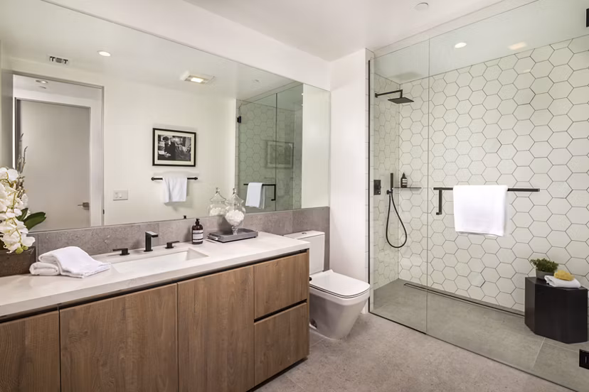 Bathroom with marble countertops and sleek fixtures at The Alfred Apartments
