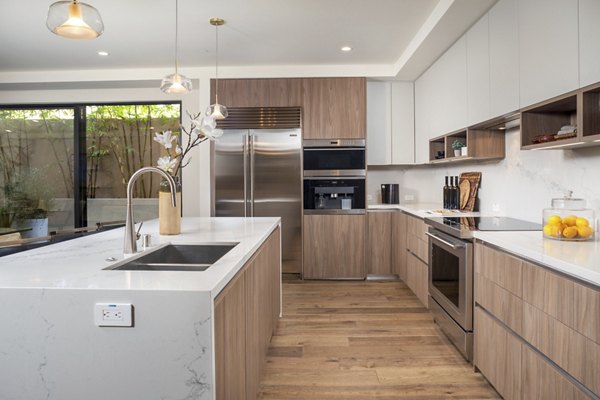 Modern kitchen with sleek cabinetry and stainless-steel appliances at The Alfred Apartments