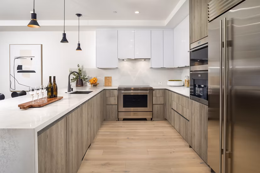Modern kitchen with stainless steel appliances and quartz countertops at The Alfred Apartments, luxury living in the heart of the city