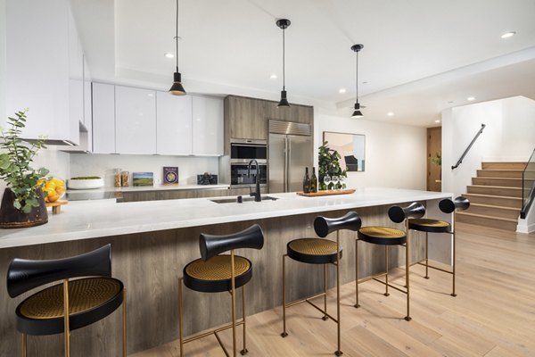 Modern kitchen featuring stainless steel appliances and quartz countertops at The Alfred Apartments