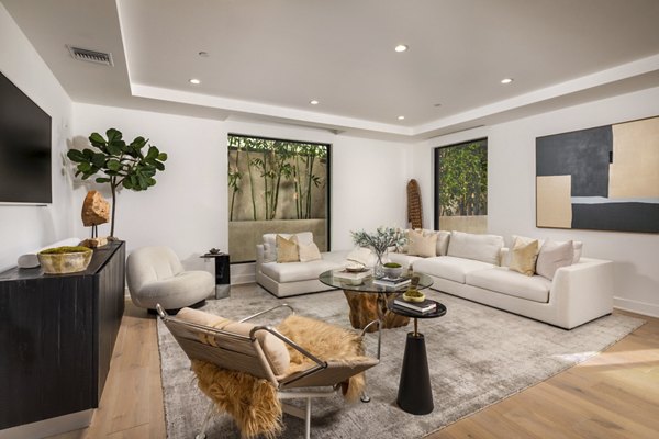 Modern living room with chic furnishings and natural light at The Alfred Apartments
