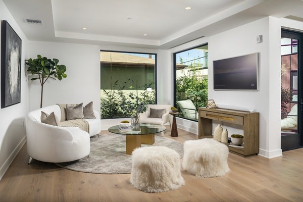 Modern living room with sleek furnishings and large windows in The Alfred Apartments
