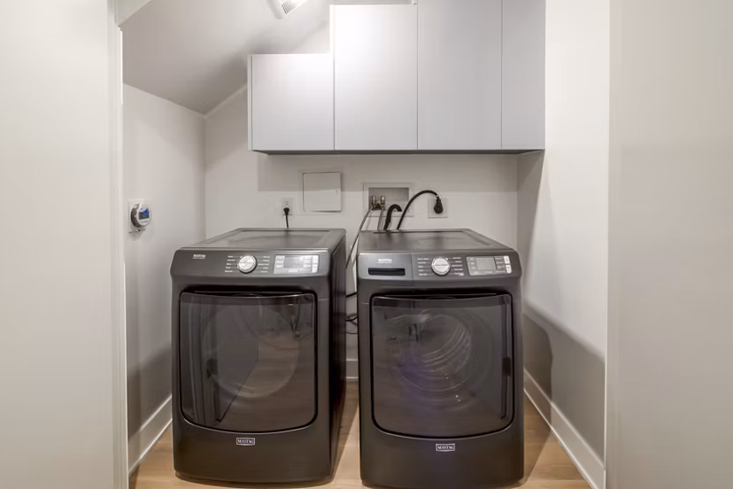 Laundry room with high-efficiency washers and dryers in The Alfred Apartments, a luxury Greystar property in a prime location