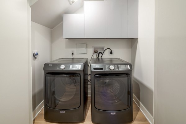 Laundry room with high-efficiency washers and dryers in The Alfred Apartments, a luxury Greystar property in a prime location
