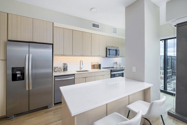 Modern kitchen with sleek countertops and stainless steel appliances at 400H Apartments luxury homes by Greystar