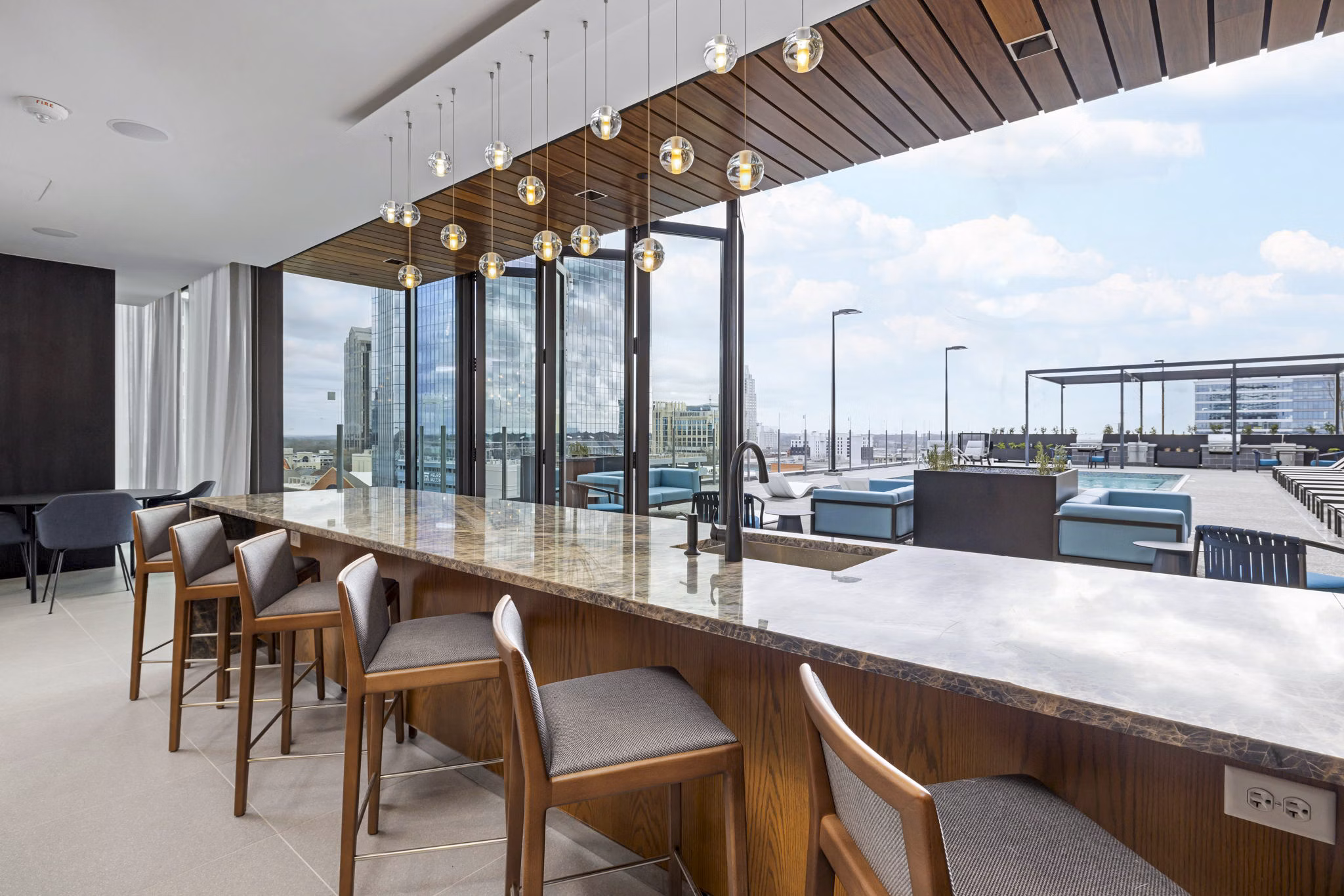 Stylish outdoor patio area at 400H Apartments, featuring modern seating and lush greenery