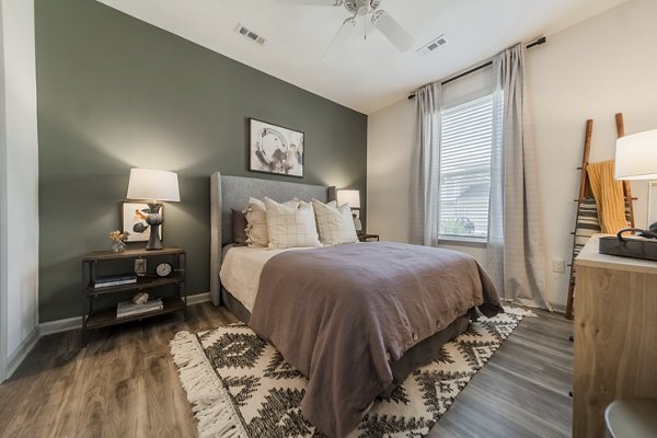 Comfortable bedroom with natural lighting at Pringle Square Apartments, offering luxury living in serene surroundings