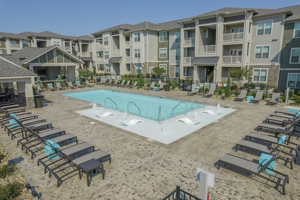 Relaxing outdoor pool at Pringle Square Apartments with resort-style seating and lush greenery, perfect for leisure and recreation