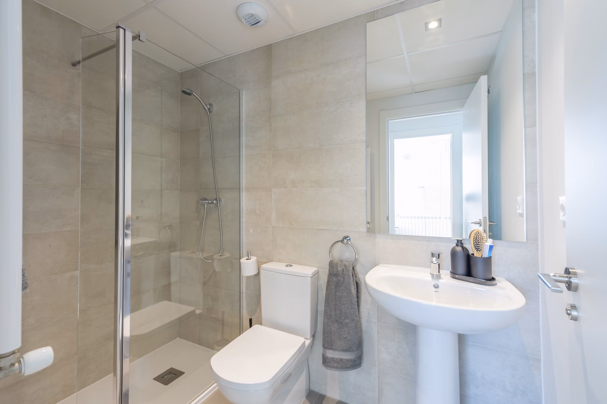 Modern bathroom with a sink, mirror, and shower at Be Casa Essential Canaveral.
