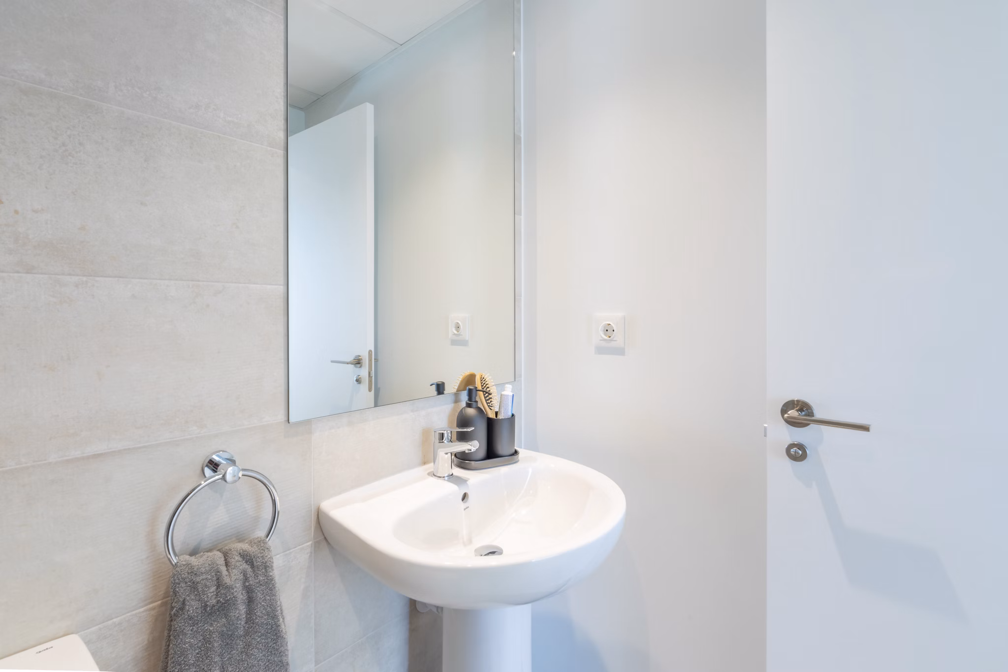 Clean and bright bathroom featuring a sleek sink and mirror at Be Casa Essential Canaveral.
