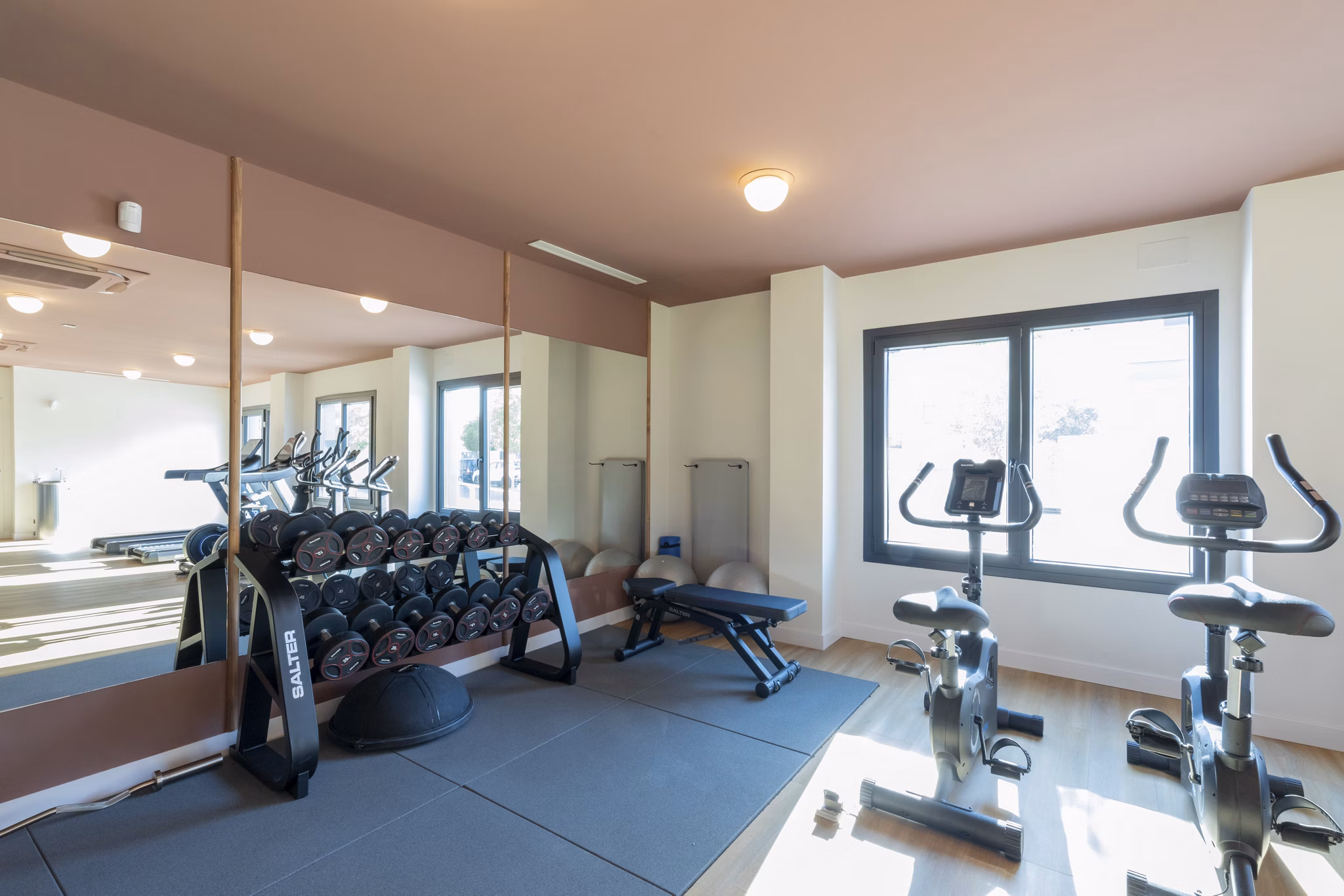 Fully equipped fitness room with cardio and strength training equipment at Be Casa Essential Canaveral.