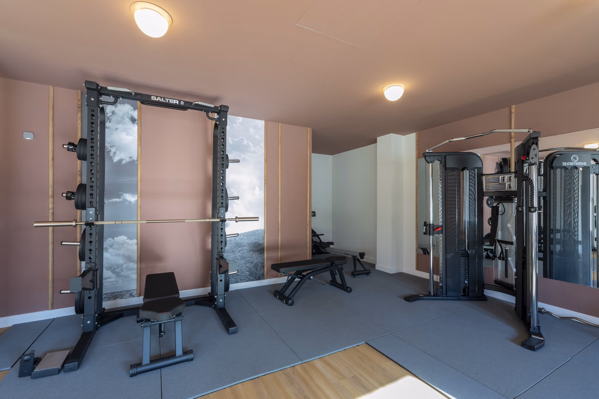 Well-lit fitness space with weight racks and exercise machines at Be Casa Essential Canaveral.