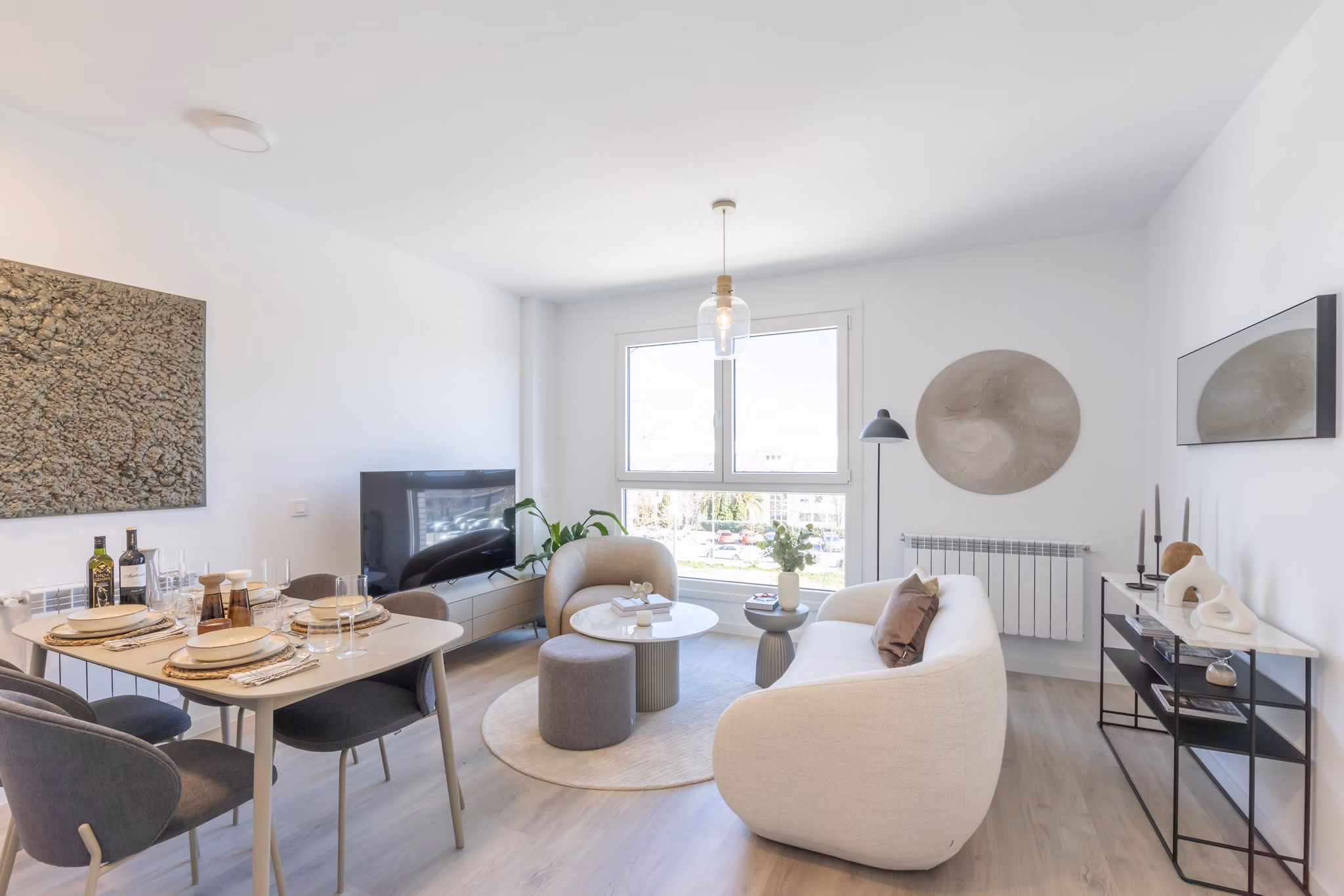 Open-plan living area with stylish furniture and bright natural light at Be Casa Essential Barajas.