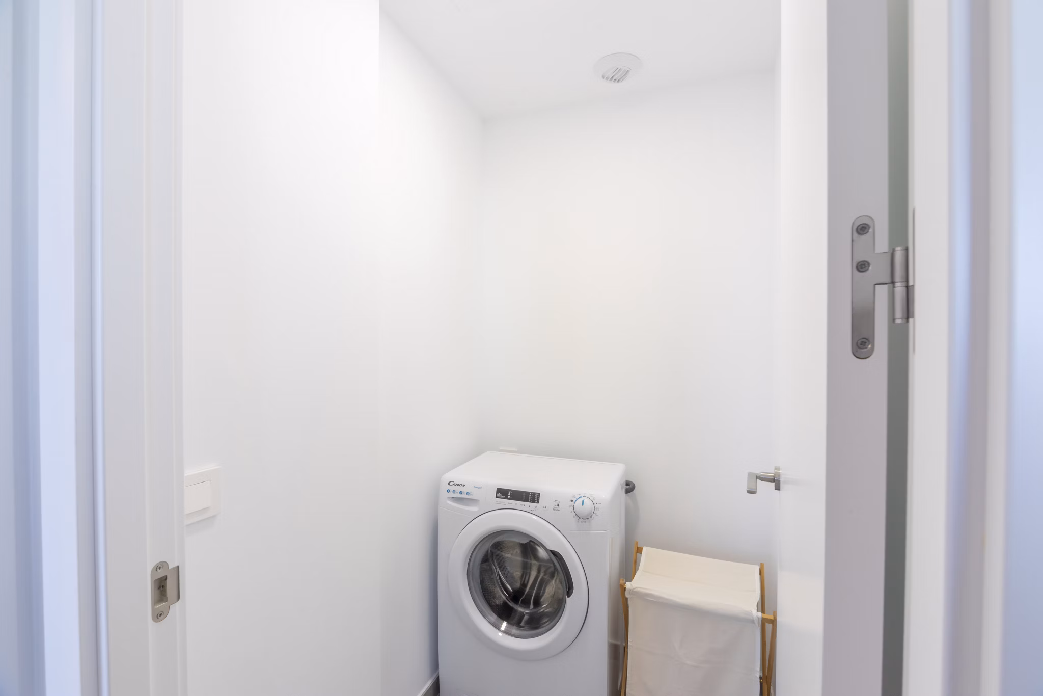 Compact laundry area with a washing machine at Be Casa Essential Barajas.