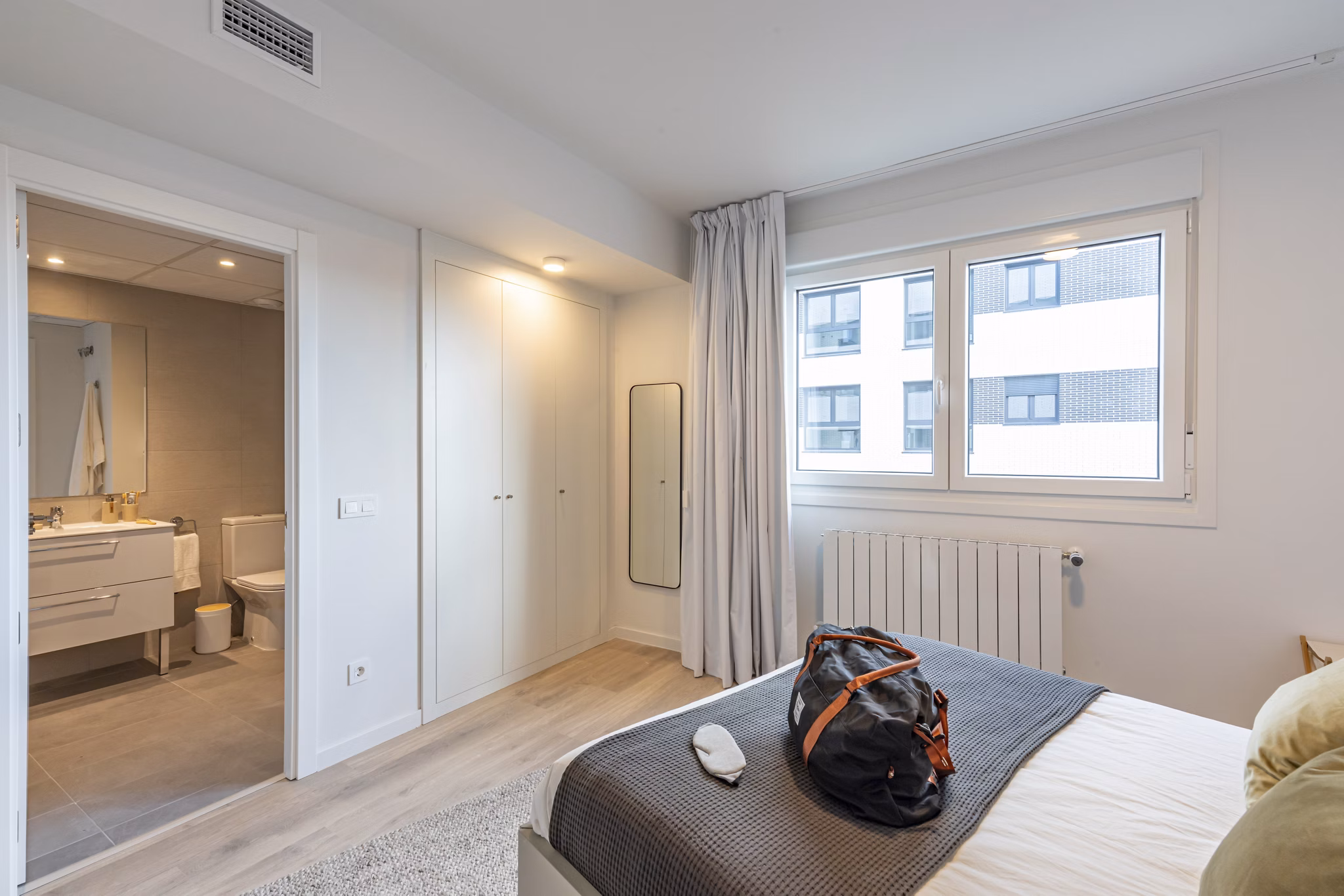 Bright and cozy bedroom with a large window and comfortable bedding at Be Casa Essential Barajas Bulevar.