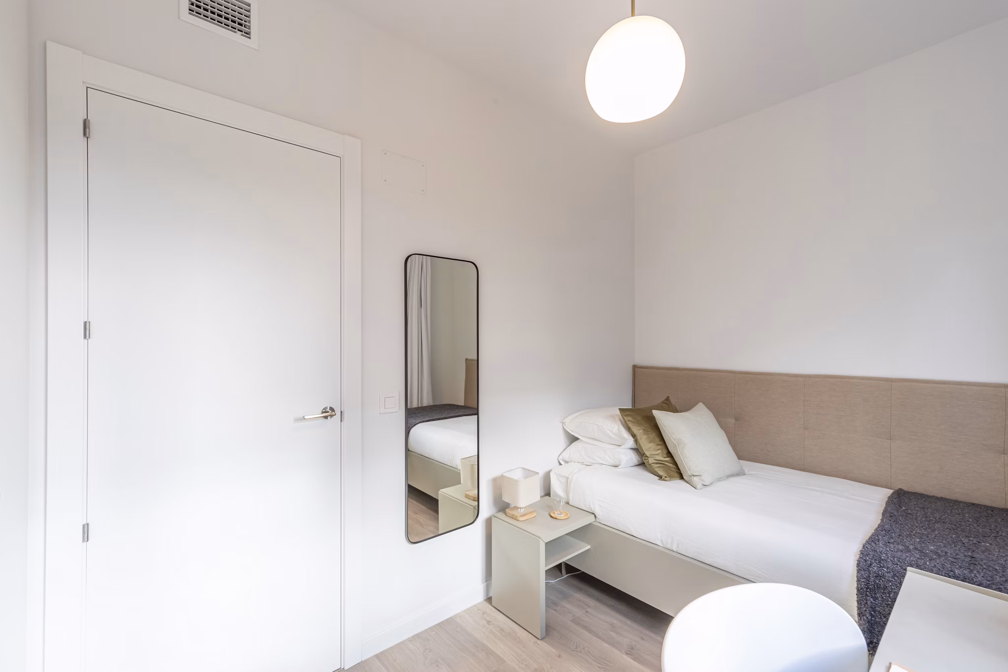 Minimalist bedroom with clean lines and cozy furnishings at Be Casa Essential Barajas Bulevar.