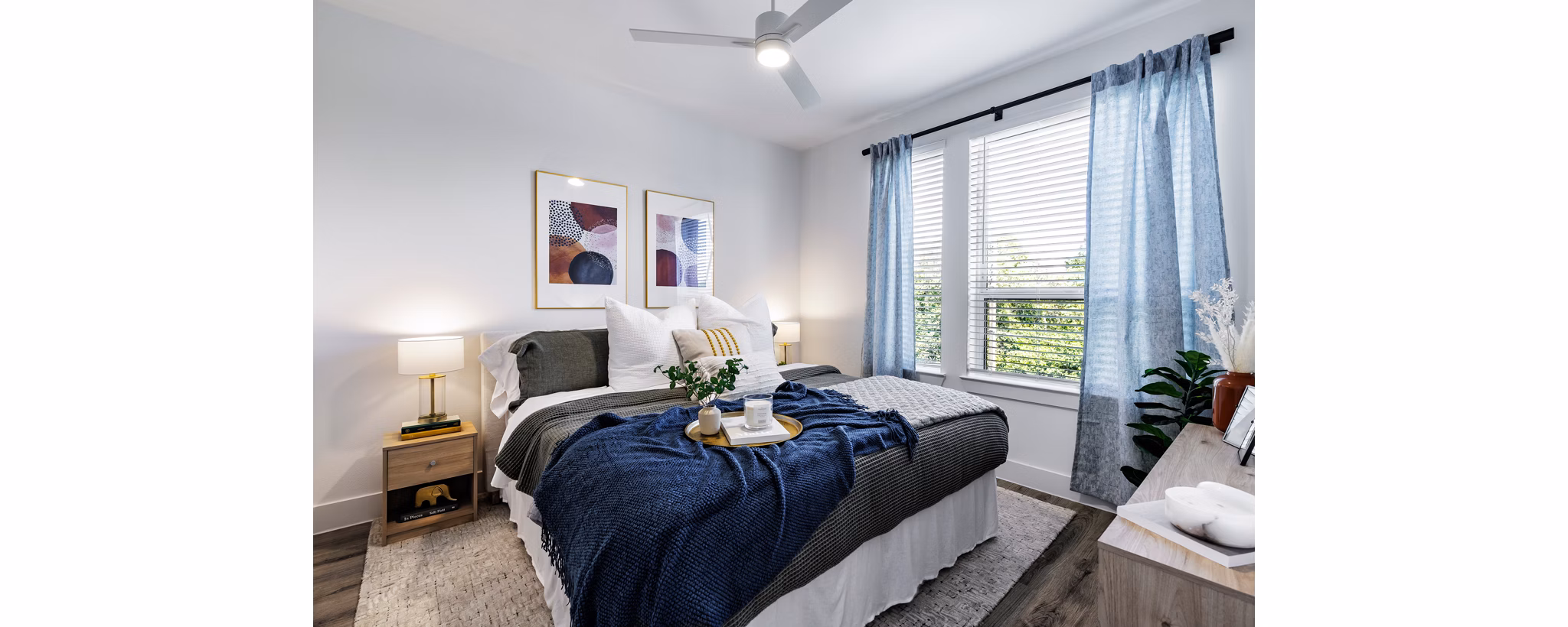 Cozy bedroom with modern furnishings at Crosstown Apartments, showcasing luxury living in a premier location
