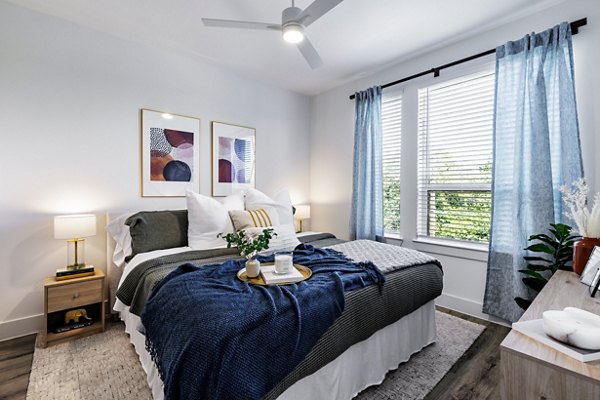 Cozy bedroom with modern furnishings at Crosstown Apartments, showcasing luxury living in a premier location