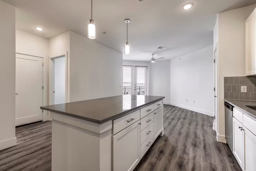 Modern kitchen with granite countertops and stainless steel appliances in Crosstown Apartments
