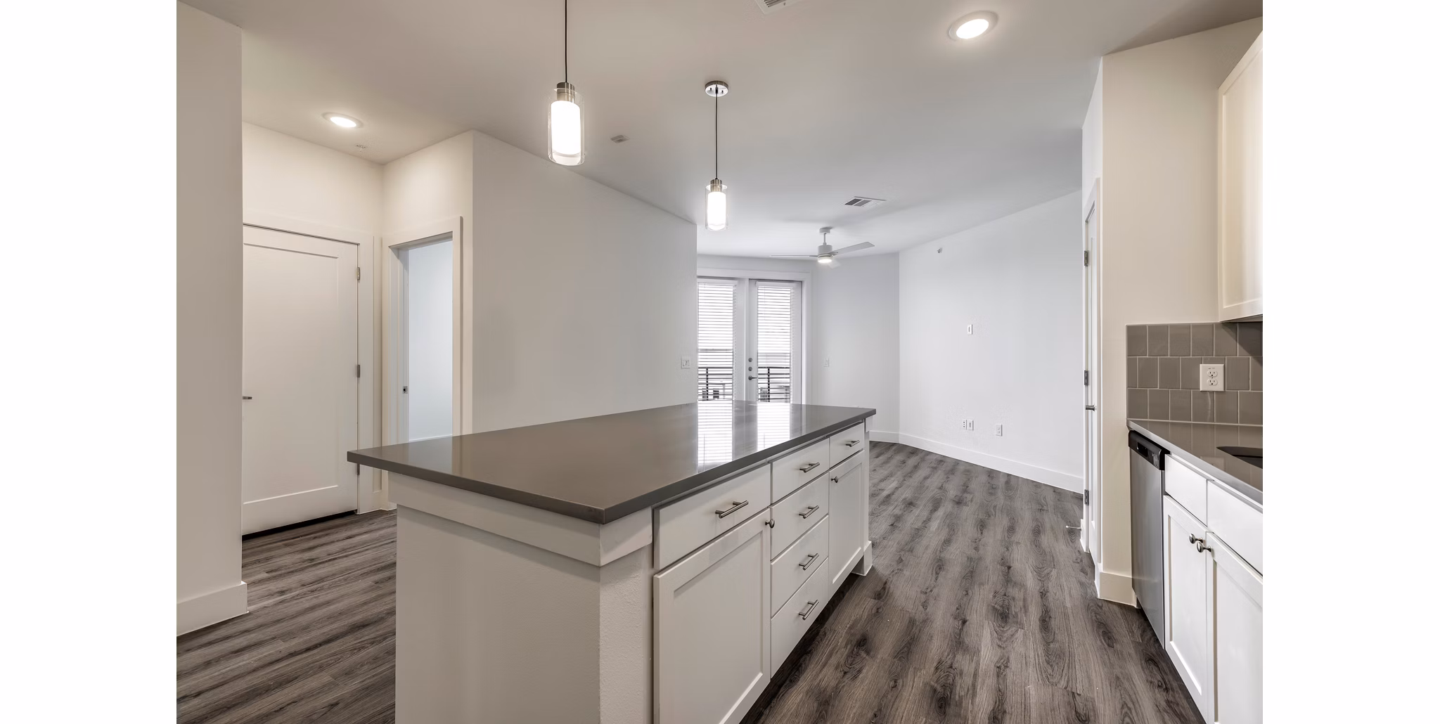 Modern kitchen with granite countertops and stainless steel appliances in Crosstown Apartments
