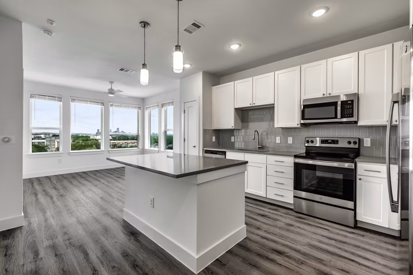 Sleek kitchen with stainless steel appliances and granite countertops at Crosstown Apartments