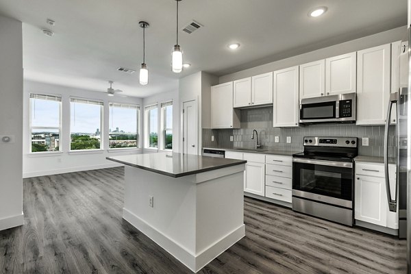 Sleek kitchen with stainless steel appliances and granite countertops at Crosstown Apartments