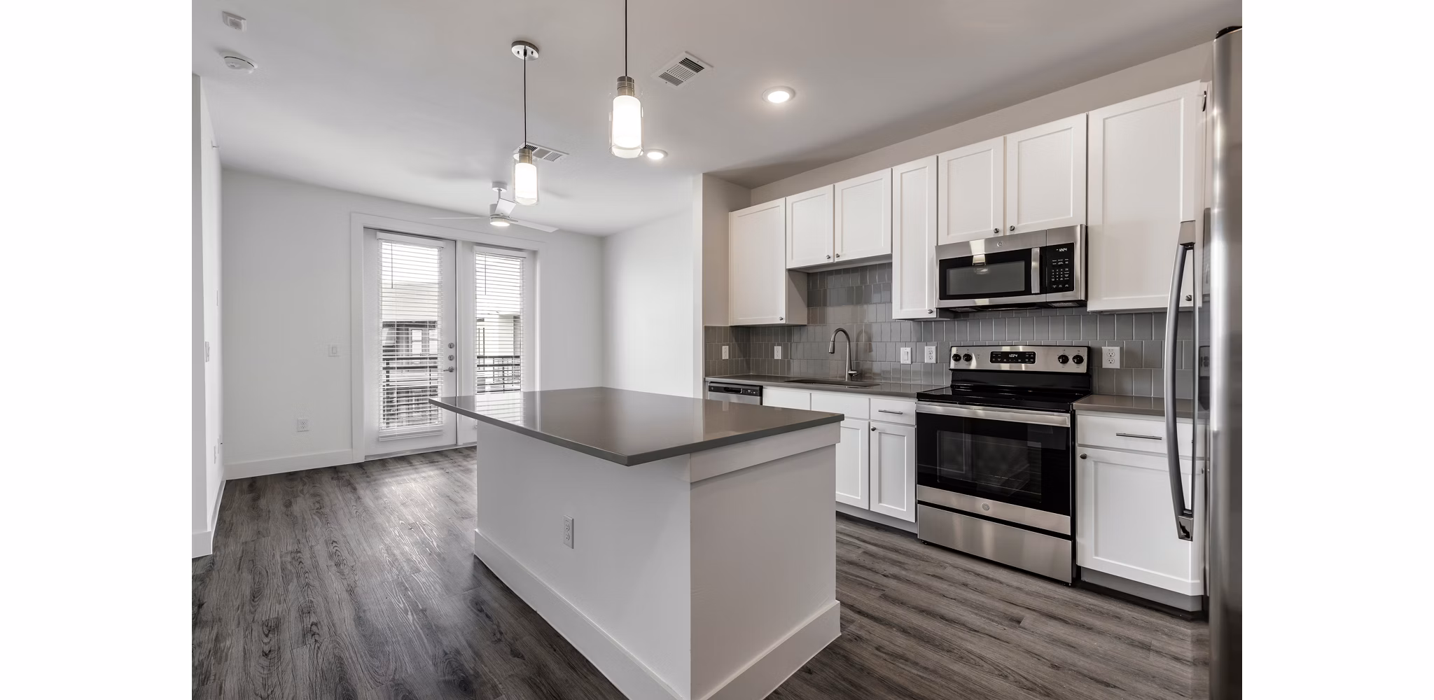 Modern kitchen with stainless steel appliances and granite countertops at Crosstown Apartments