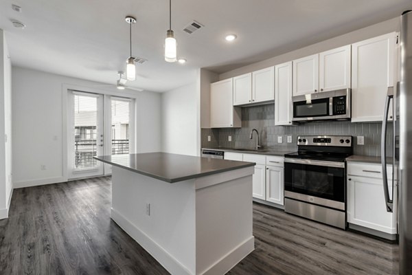 Modern kitchen with stainless steel appliances and granite countertops at Crosstown Apartments