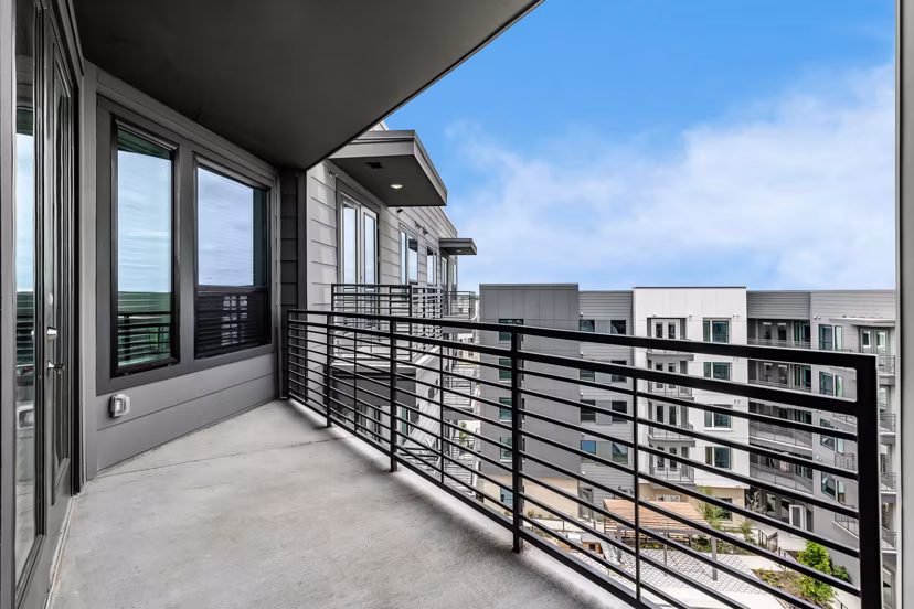 Spacious patio with stylish seating and greenery at Crosstown Apartments, perfect for relaxation and community gatherings