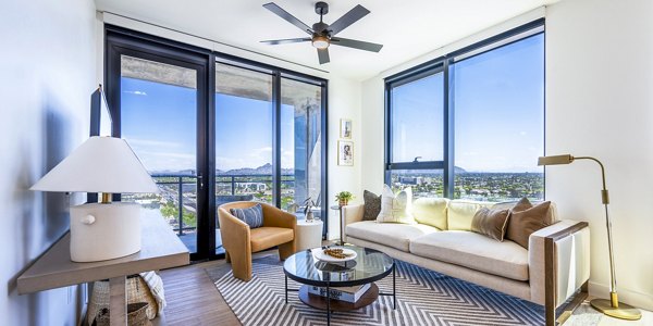 Skye on 6th Apartments: Modern living room with sleek furniture and large windows offering city views