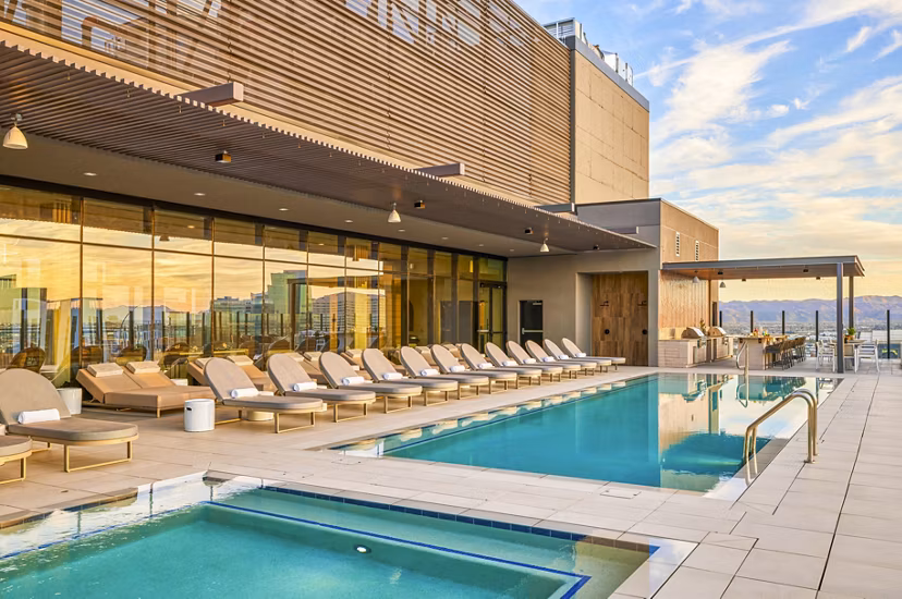 Luxury pool with shaded lounge chairs at Skye on 6th Apartments
