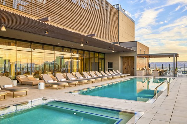 Luxury pool with shaded lounge chairs at Skye on 6th Apartments