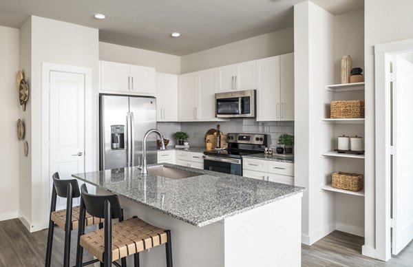 Modern kitchen with marble countertops and stainless steel appliances in Prose District West Apartments