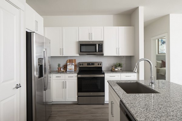 Modern kitchen with stainless steel appliances in Prose District West Apartments, offering luxury living spaces