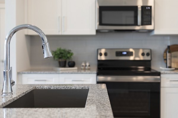 Modern kitchen with sleek countertops and stainless steel appliances at Prose District West Apartments