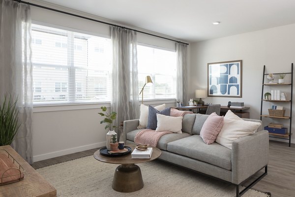 Living room featuring modern furnishings and natural light at Prose District West Apartments