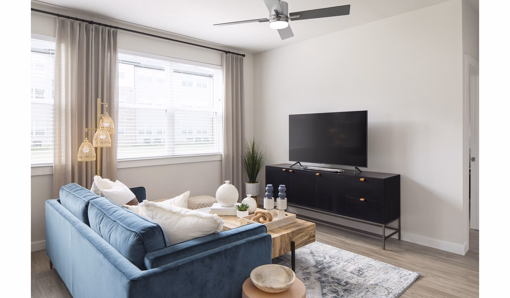 Living room with modern decor and ample natural light at Prose District West Apartments