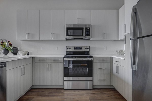 Modern kitchen with sleek stainless steel appliances in Bowers Apartments