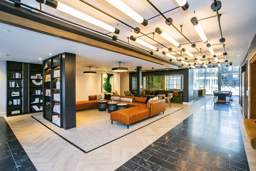 Clubhouse with modern furnishings and vibrant decor at Tanager Echo Apartments, a Greystar luxury community