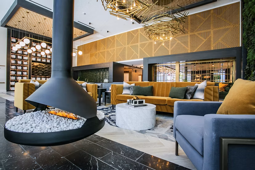 Modern clubhouse with lounge seating and fireplace at Tanager Echo Apartments