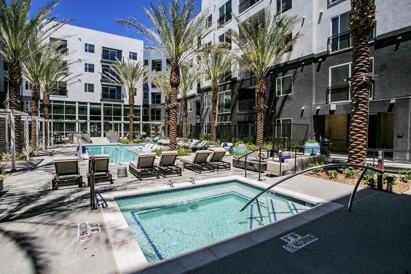 Resort-style pool with lounge chairs at Tanager Echo Apartments for luxury living