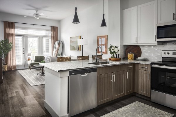 Modern kitchen with stainless steel appliances at Adaline at the Station Apartments